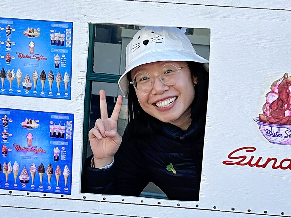A woman with a cat bucket hat holding a peace sign.